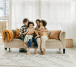 two parents and two kids sitting on sofa