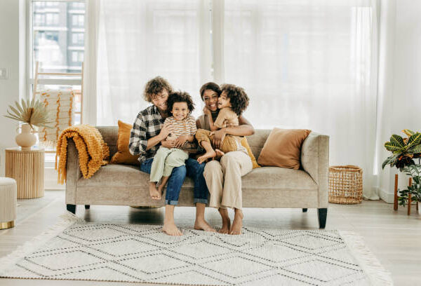 two parents and two kids sitting on sofa